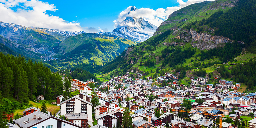 Switzerland travel places to visit with scenic Alps, lakes and charming villages.Traditional Swiss food including fondue, raclette and rösti