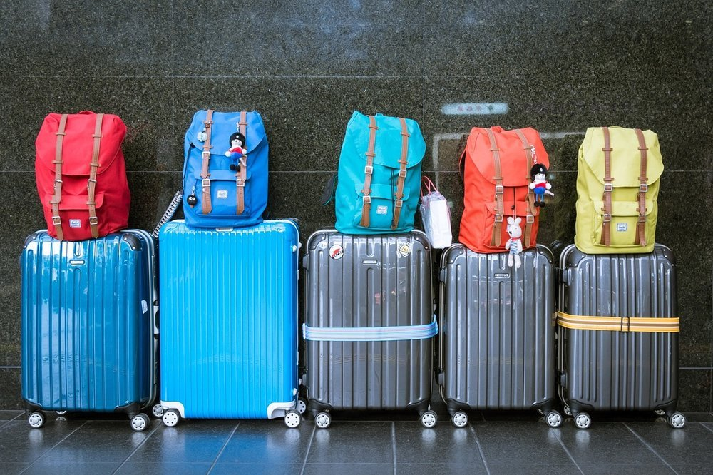 Travel budget planning with maps, currency, and booking details.Carry-on bag packed with essential items for a trip.